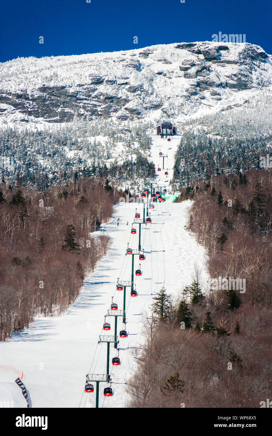 Stowe, VT, USA - Mar 17, 2005: The gondola lift to the top of the Stowe Mountain Resort over a green dyed waterfall for St. Patricks Day Stock Photo