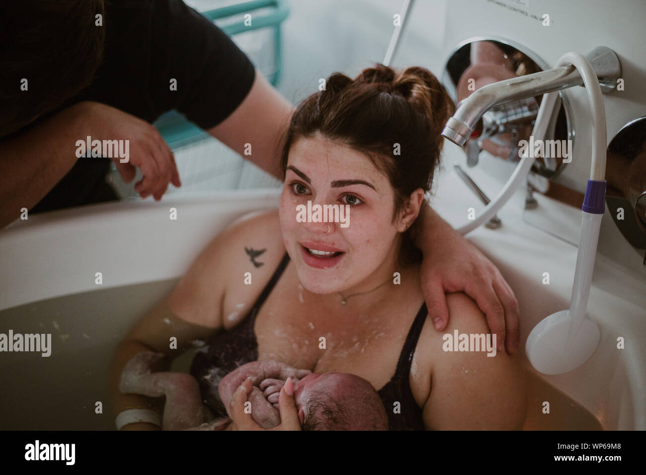 Authentic birth images, woman giving birth in pool Stock Photo