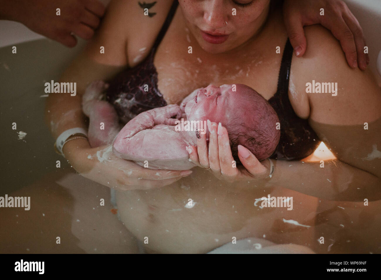 Authentic birth images, woman giving birth in pool Stock Photo