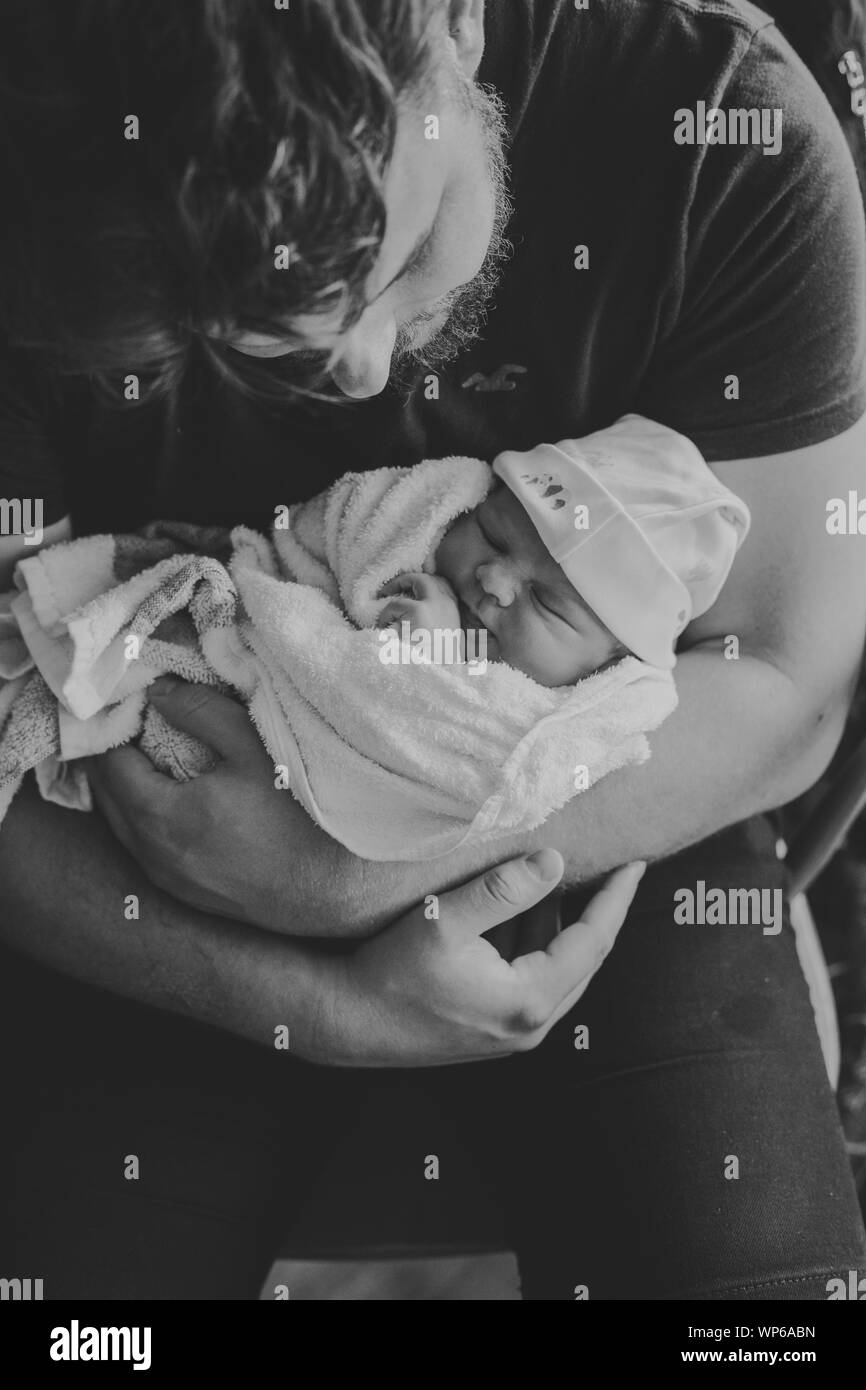 New Dad holding newborn son in hospital Stock Photo