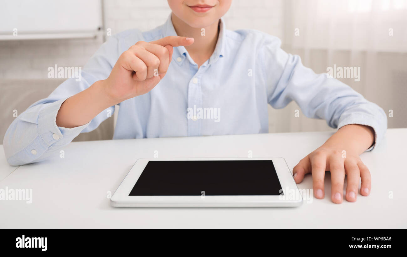 Schoolboy with tablet pc studying in classroom Stock Photo