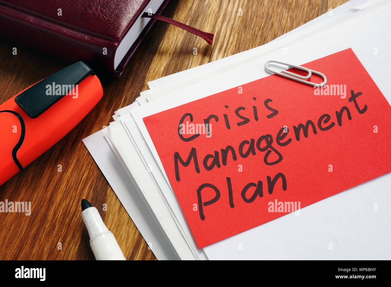 Crisis Management Plan on an office desk and papers. Stock Photo