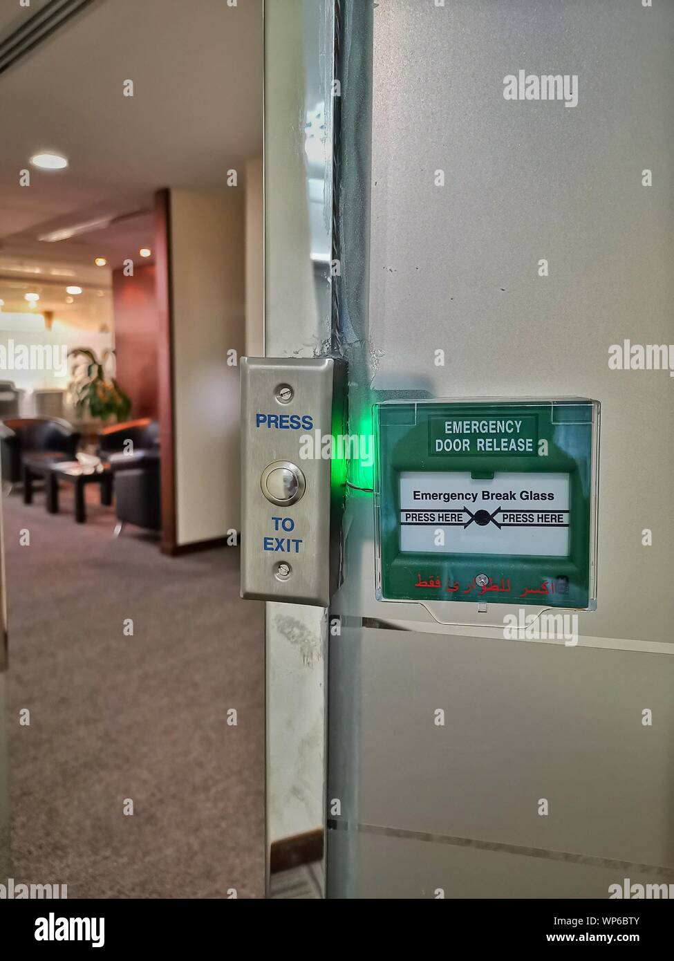 green emergency exit button to open door press here Stock Photo - Alamy