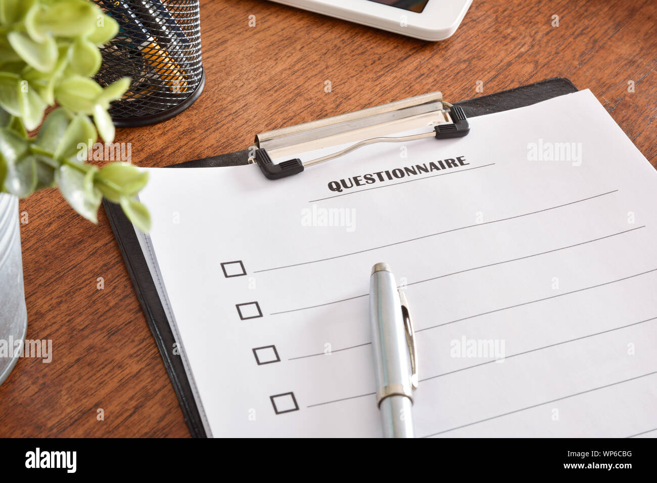 Questionnaire sheets in a folder on an office table and a pen on top. Horizontal composition. Top view. Stock Photo