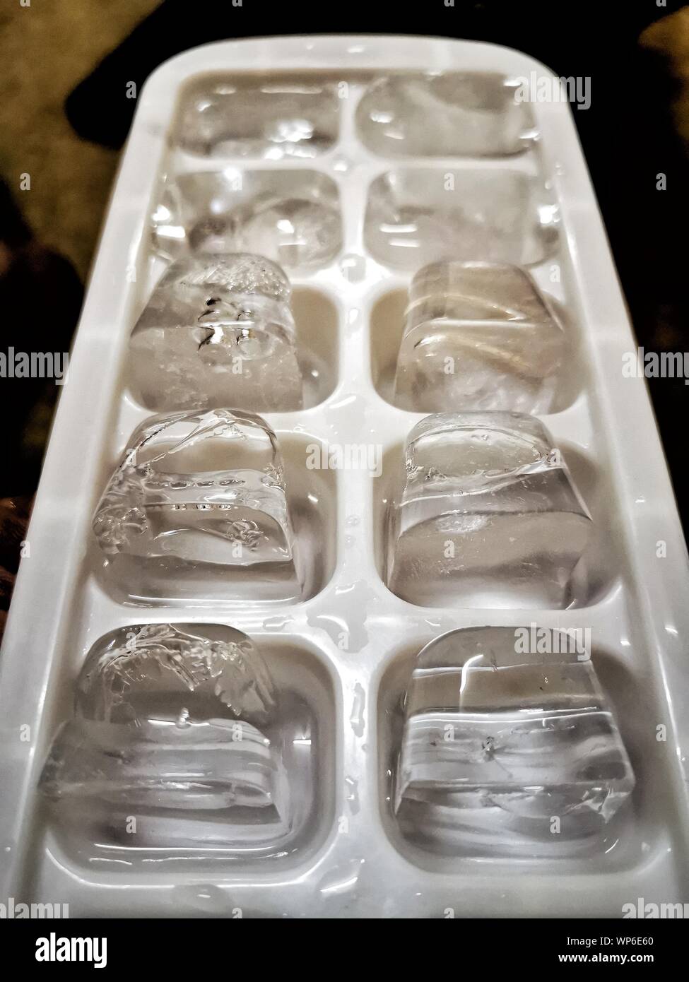 https://c8.alamy.com/comp/WP6E60/ice-cubes-closeup-white-tray-freezing-water-drops-WP6E60.jpg