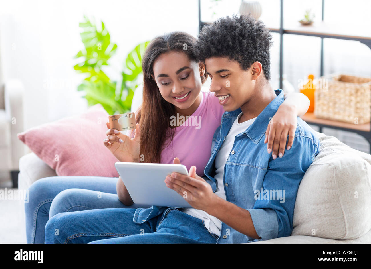 Teenage Couple Shopping Online Using Digital Tablet At Home Stock Photo