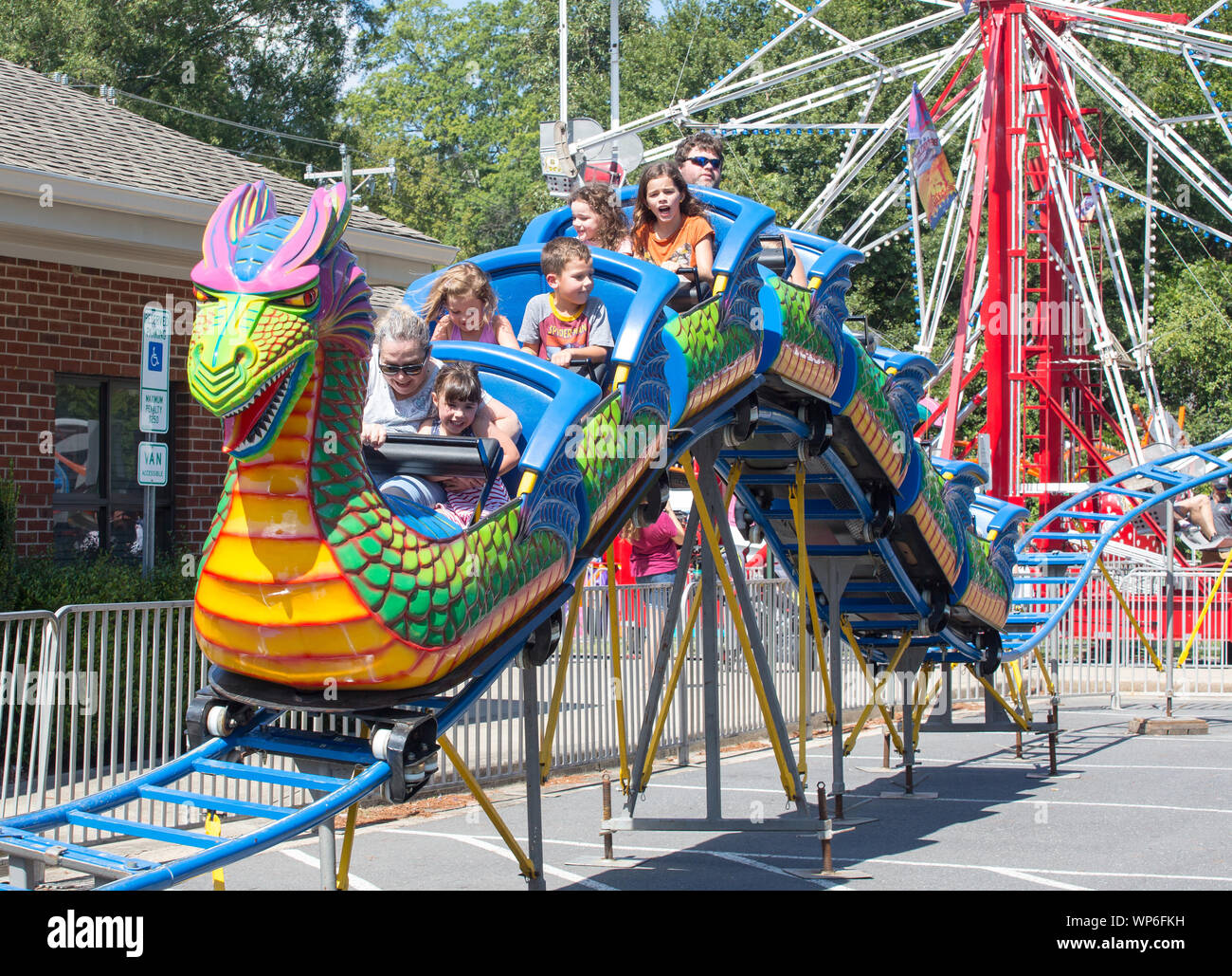 MATTHEWS, NC (USA) - August 31, 2019: Parents and Children enjoy a roller coaster ride at the annual 'Matthews Alive' community festival. Stock Photo