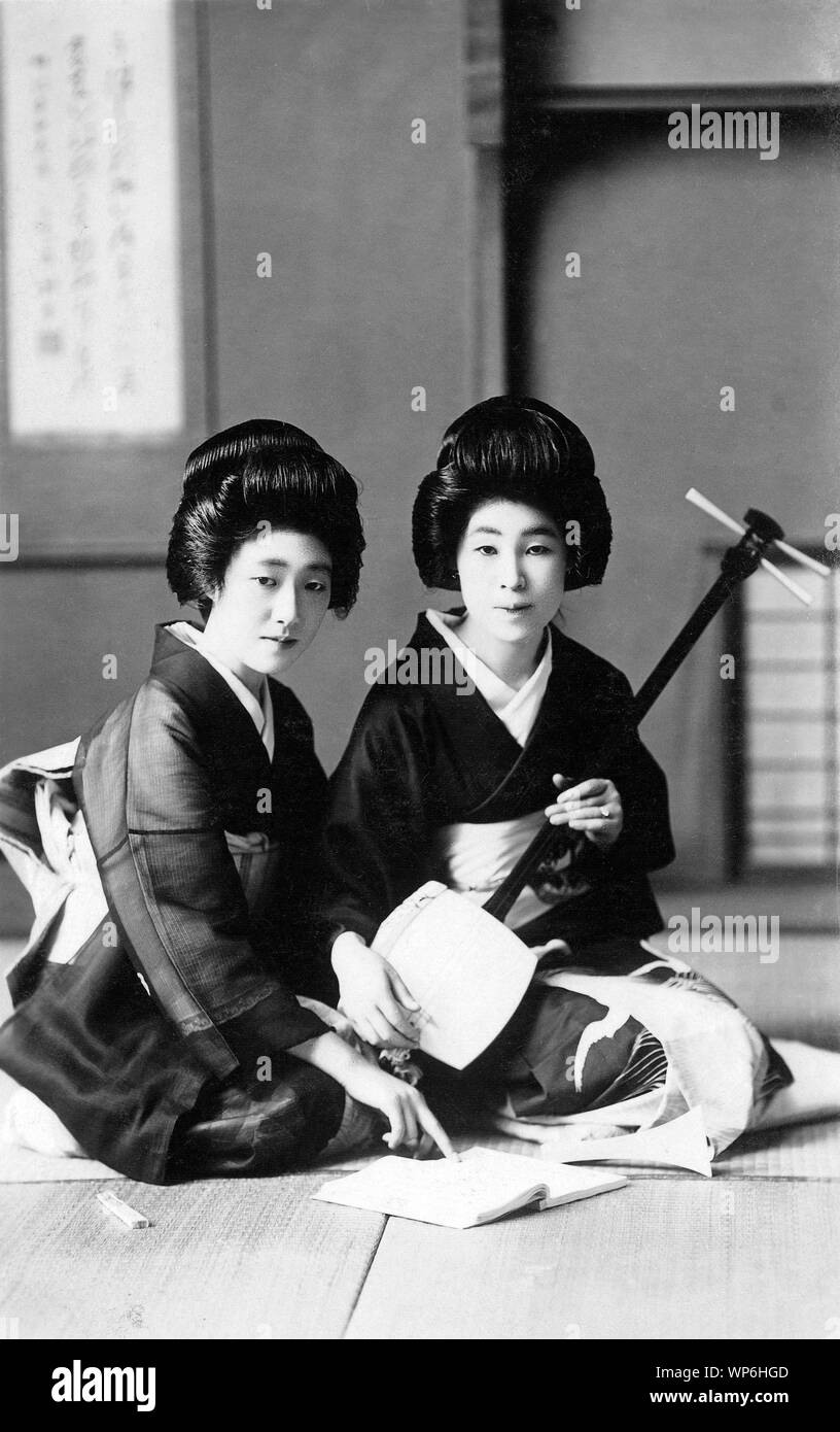 [ 1920s Japan - Japanese Geisha Practicing the Shamisen ] —   Geisha practicing the shamisen.  20th century vintage postcard. Stock Photo