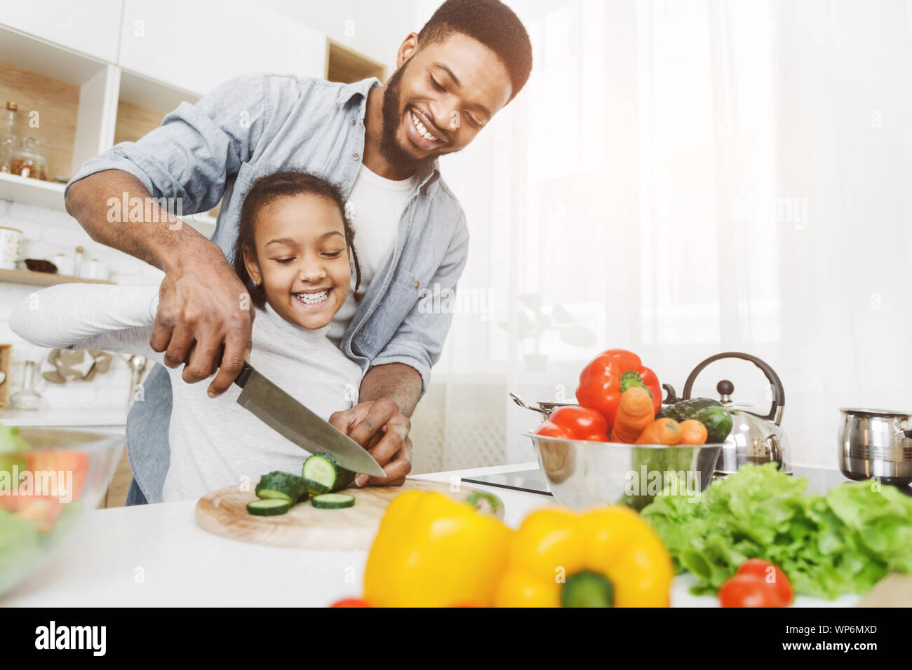 Dad teaching little girl how to use knife Stock Photo - Alamy