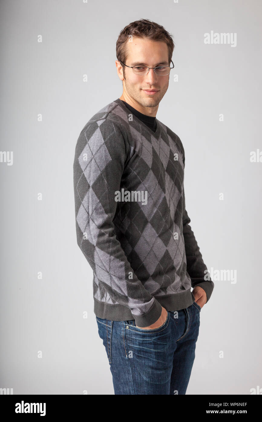 Man wearing argyle sweater, jeans and eyeglasses. Young men's casual clothing apparel styles. Stock Photo