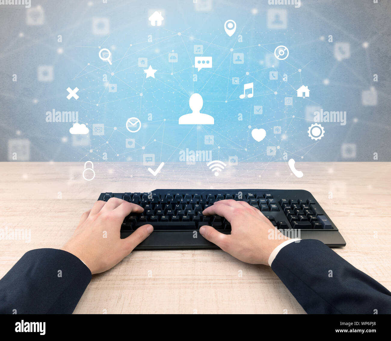 First person view of hand typing with social media concept icons around ...