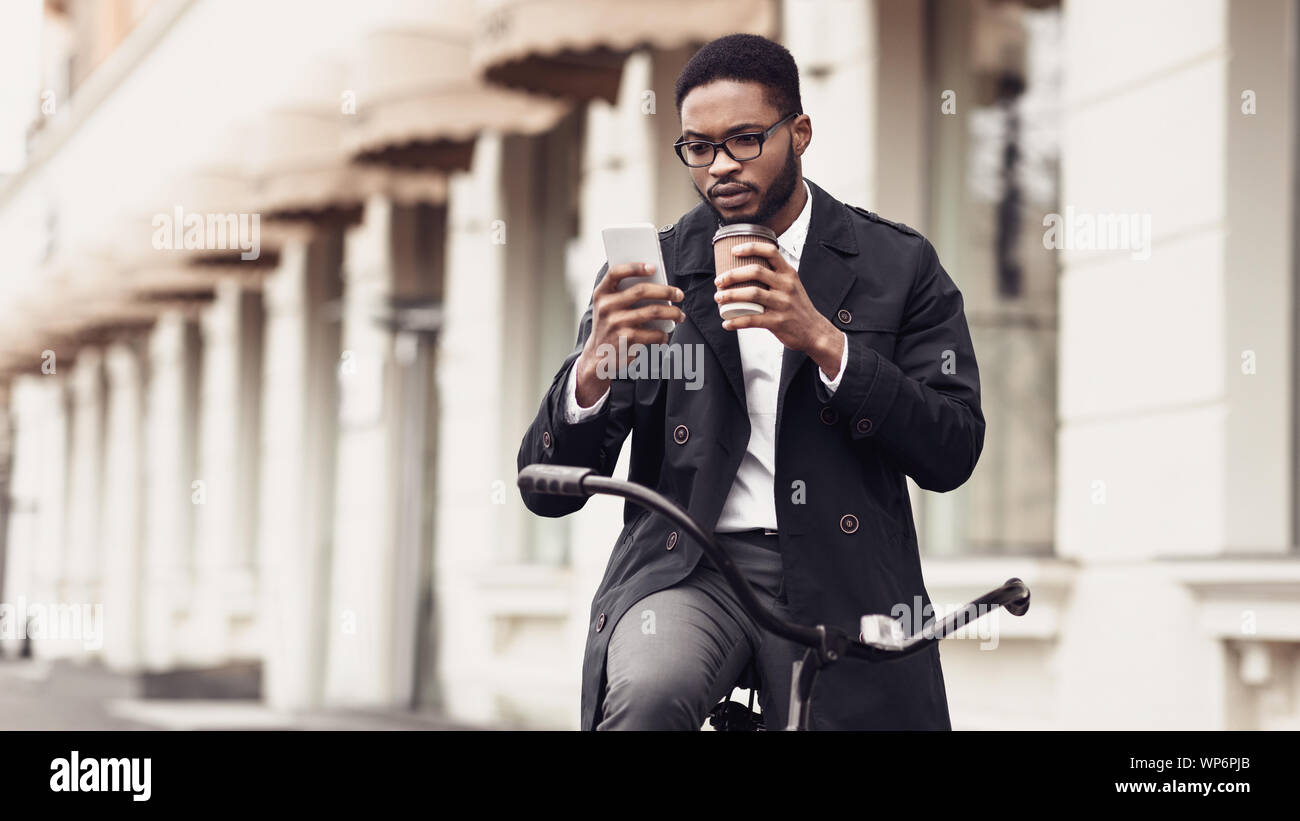 Happy businessman using mobile phone, drinking coffee outdoors Stock Photo