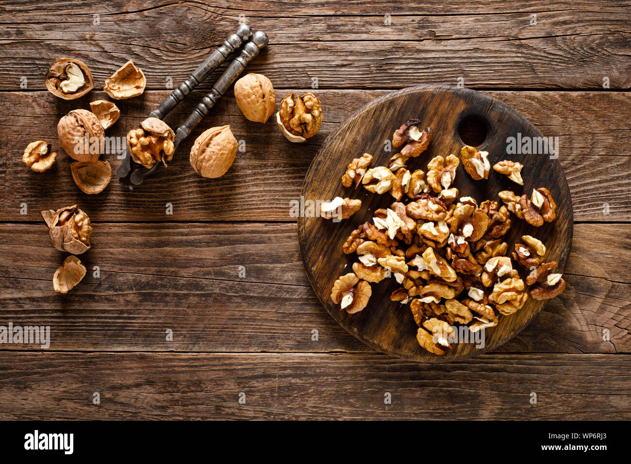 Walnuts. Kernels and whole nuts on wooden rustic table, top view Stock Photo