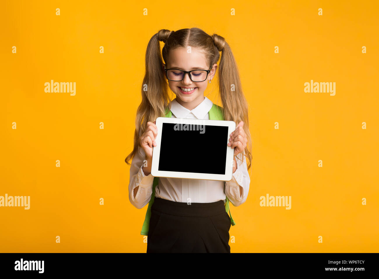 School Girl Showing Empty Tablet Screen, Yellow Background, Mockup Stock Photo Alamy