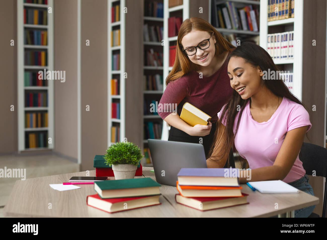Afro girl asking for help her intelligent classmate Stock Photo
