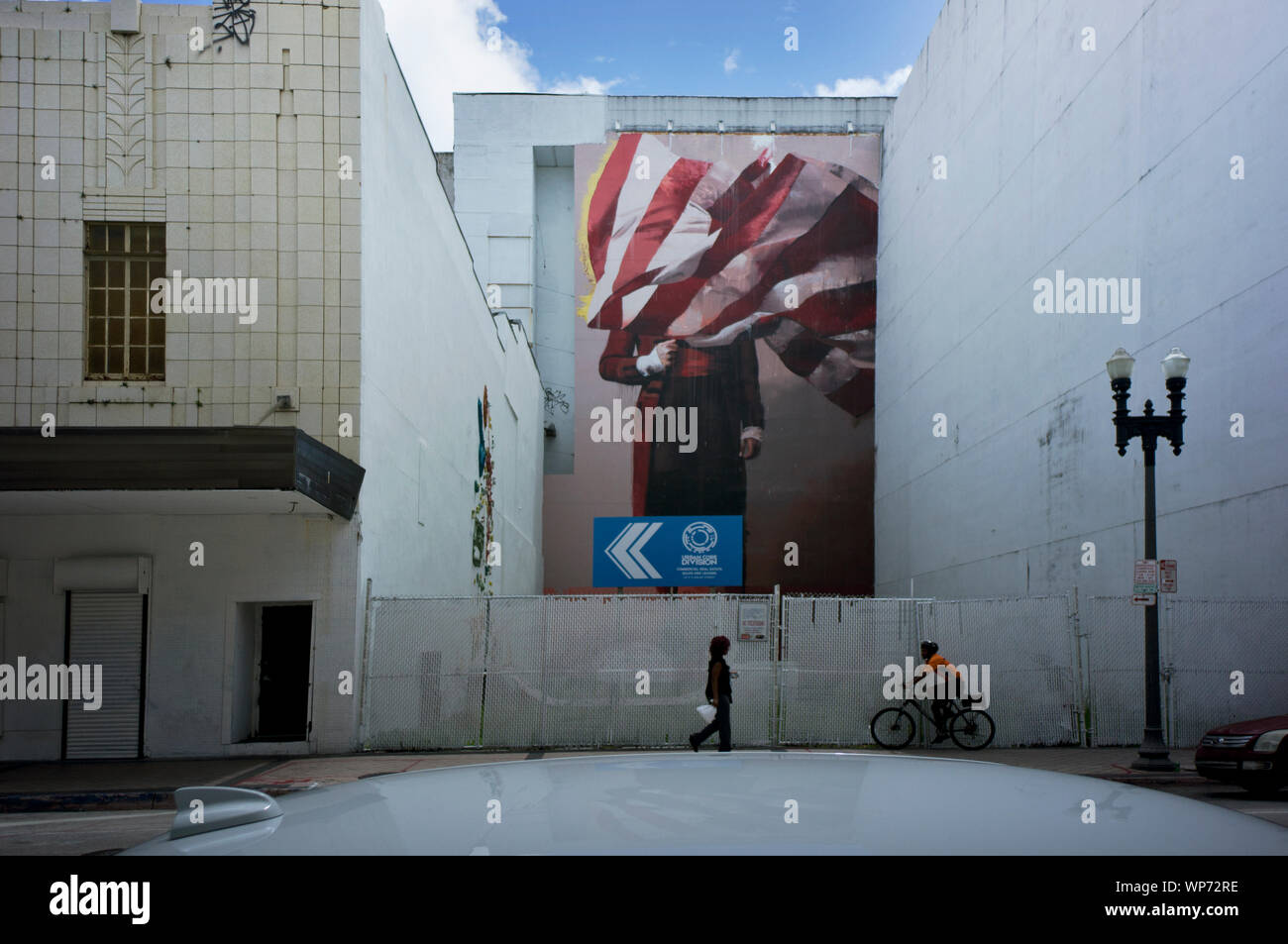 Man covered by American flag, mural by Conor Harrington in Downtown Miami,  installed in 2017 next to former Macy's building (right side of the image  Stock Photo - Alamy