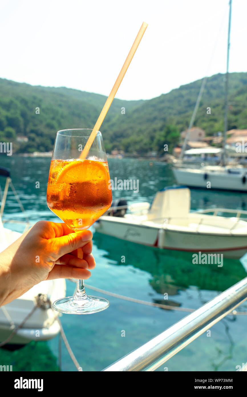 Drinking Cocktail long drink in the harbour bay with boats on a boat Stock Photo