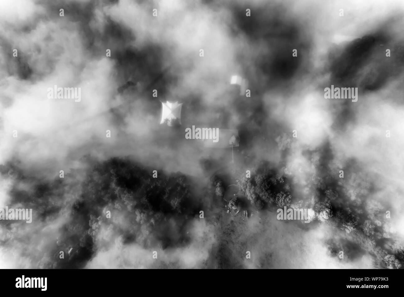 High-contrast black-wite top down view of remote farm in Kangaroo Valley of Australia covered by thick white fog. Stock Photo