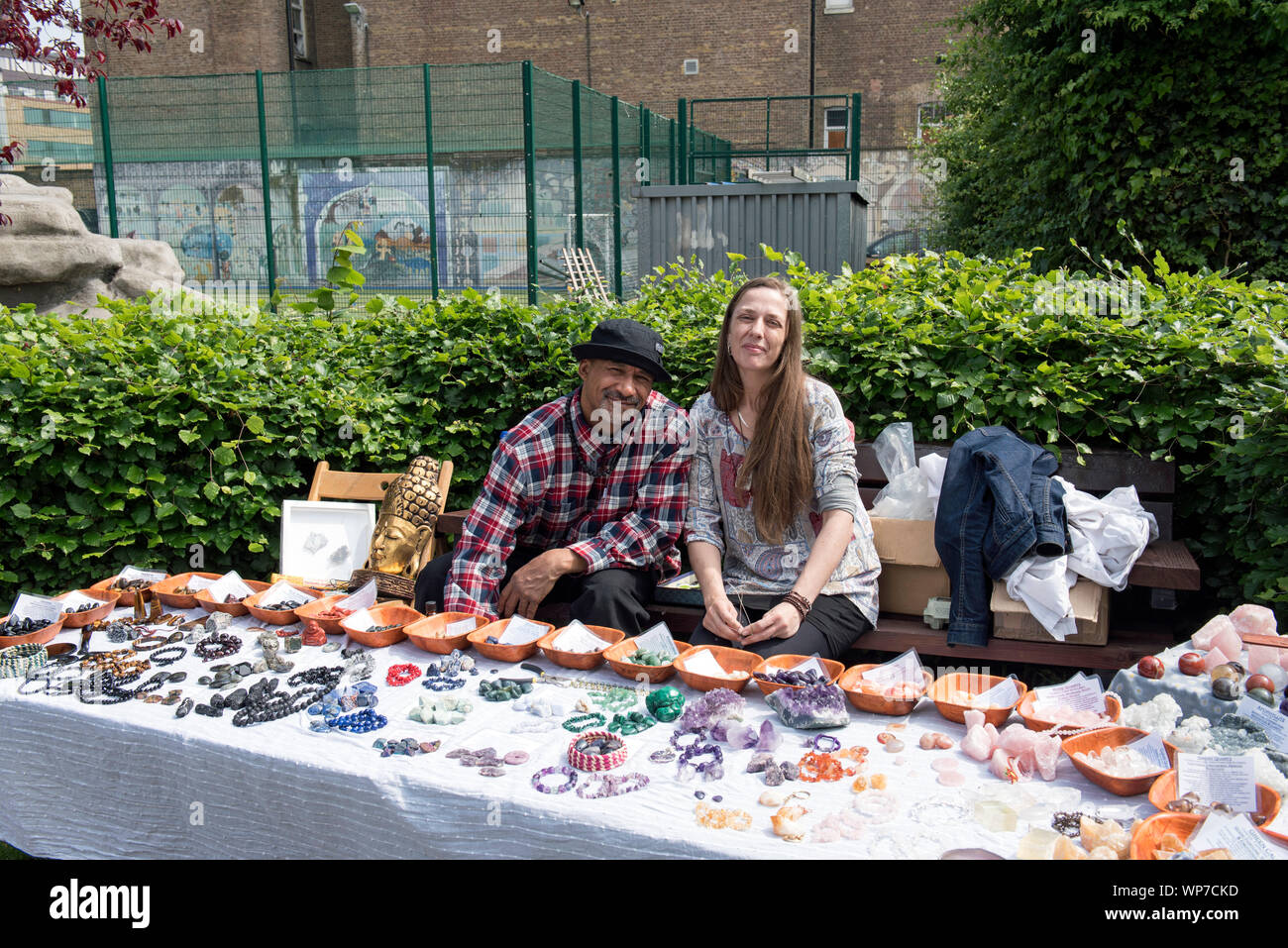 Couple behind healing gem stall at vegan festival selling stones, rocks, crystals and minerals, Calthorpe Community Garden Project, Kings Cross Stock Photo