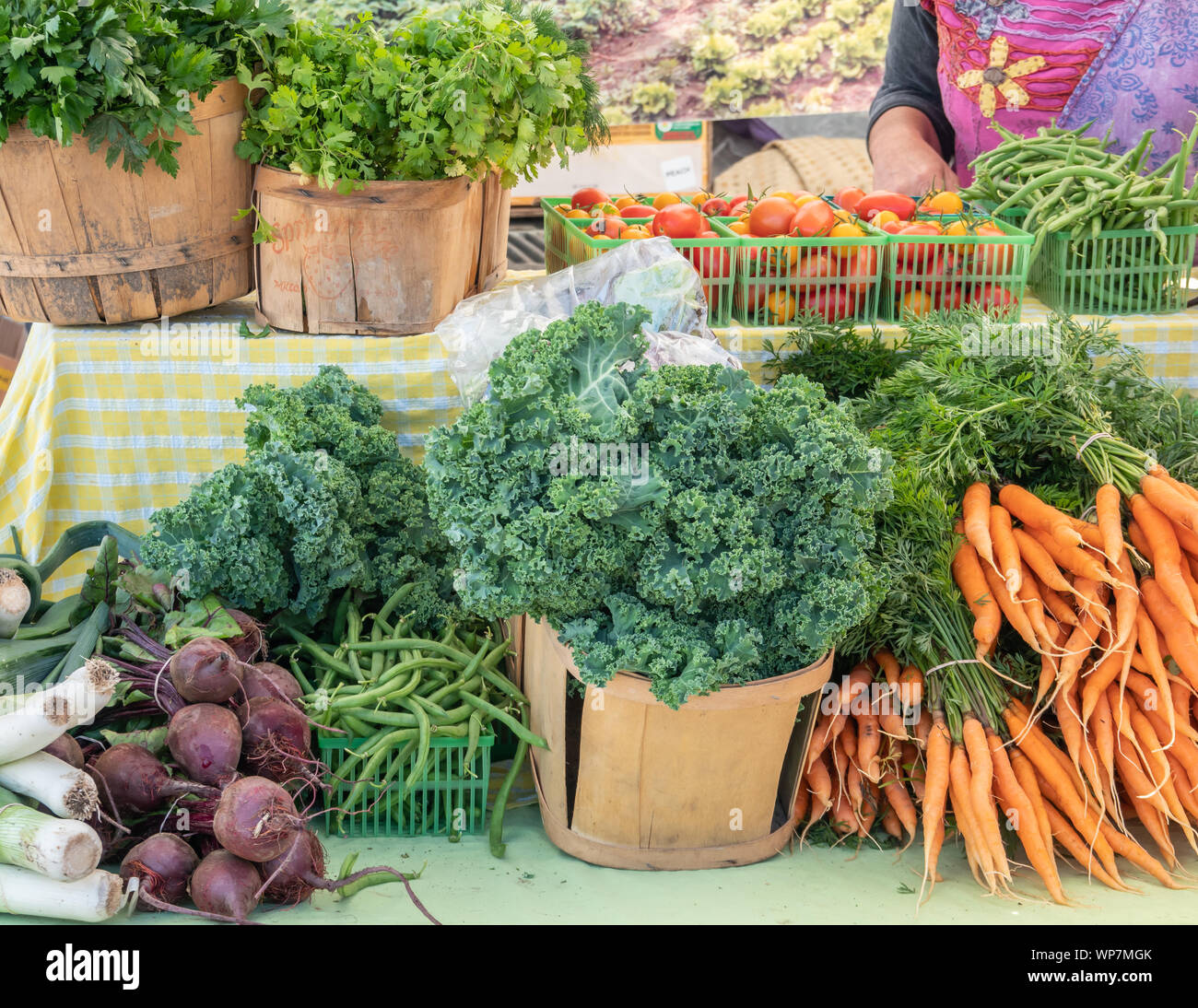 Freshly picked vegetables are presented at a stall at a local farmers market. Stock Photo