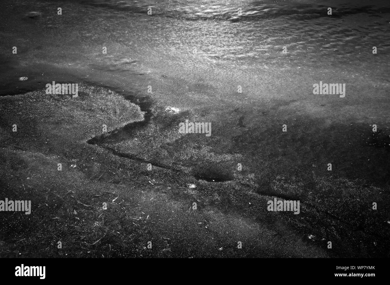 Patterns in the ice of a frozen lake in winter. Stock Photo