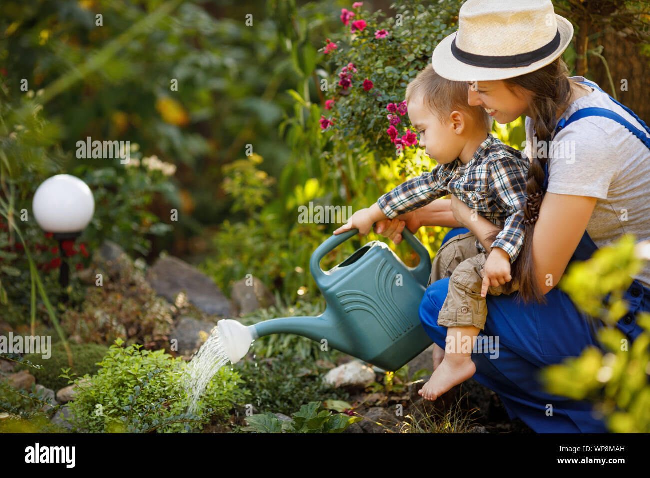 little boy and happy mother gardener with watering can Stock Photo - Alamy
