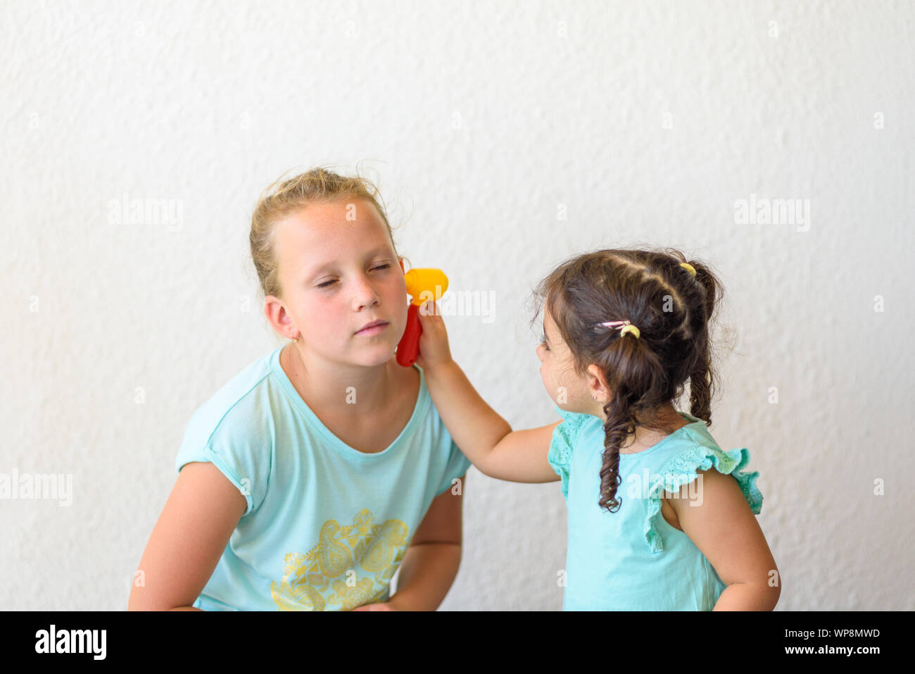 Children playing doctor. Little doctor examining patient's ear. Stock Photo