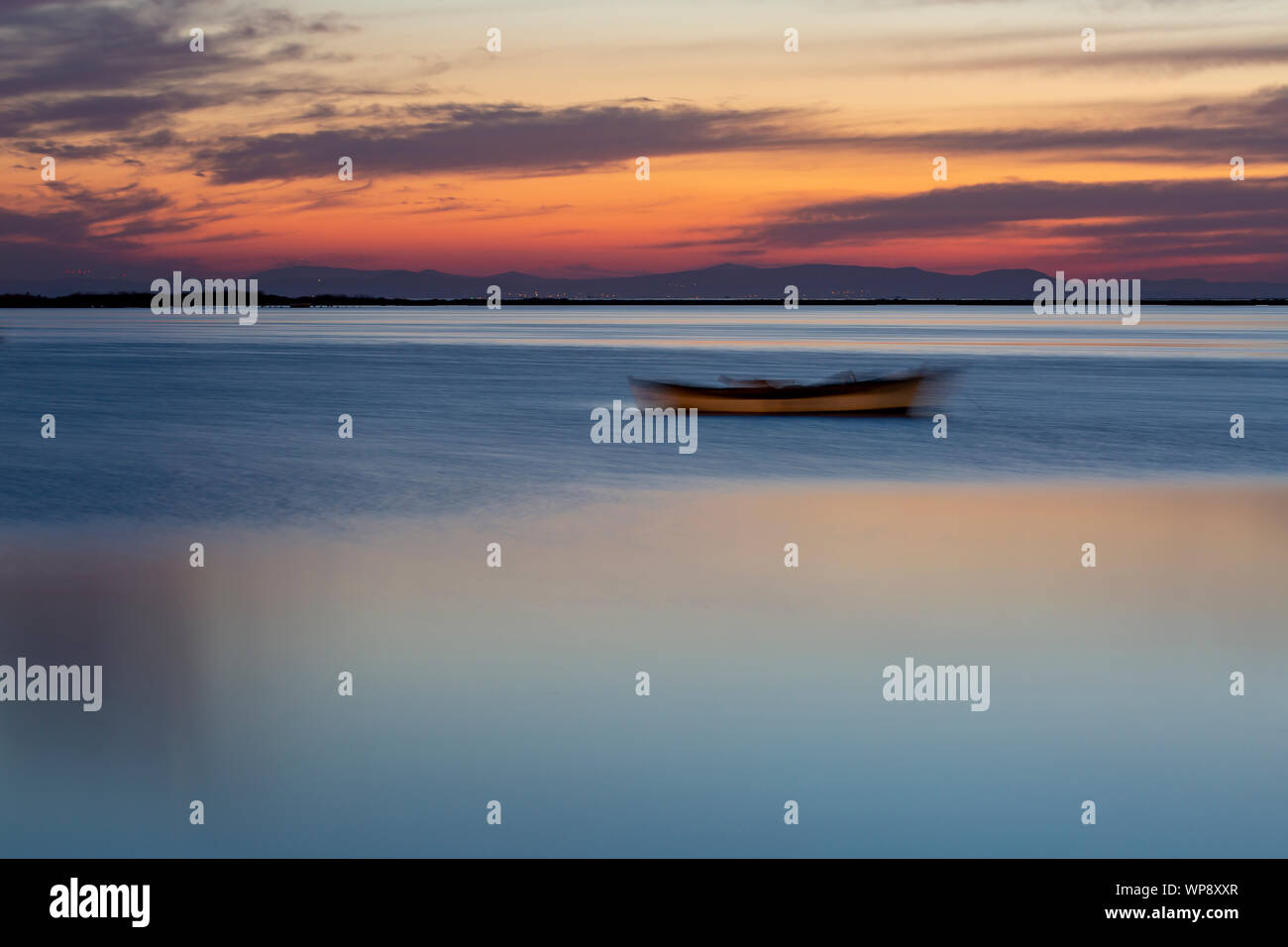 A Sailing Boat with Misty Sunset and Reflection on Water Stock Photo ...