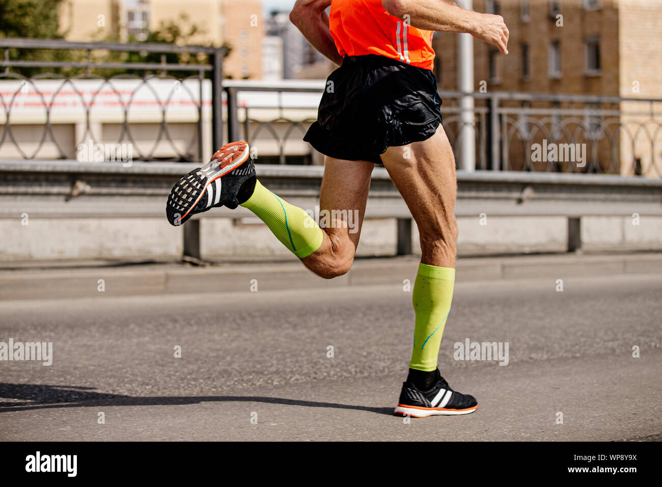 man runner in bright green compression socks running marathon Stock Photo -  Alamy