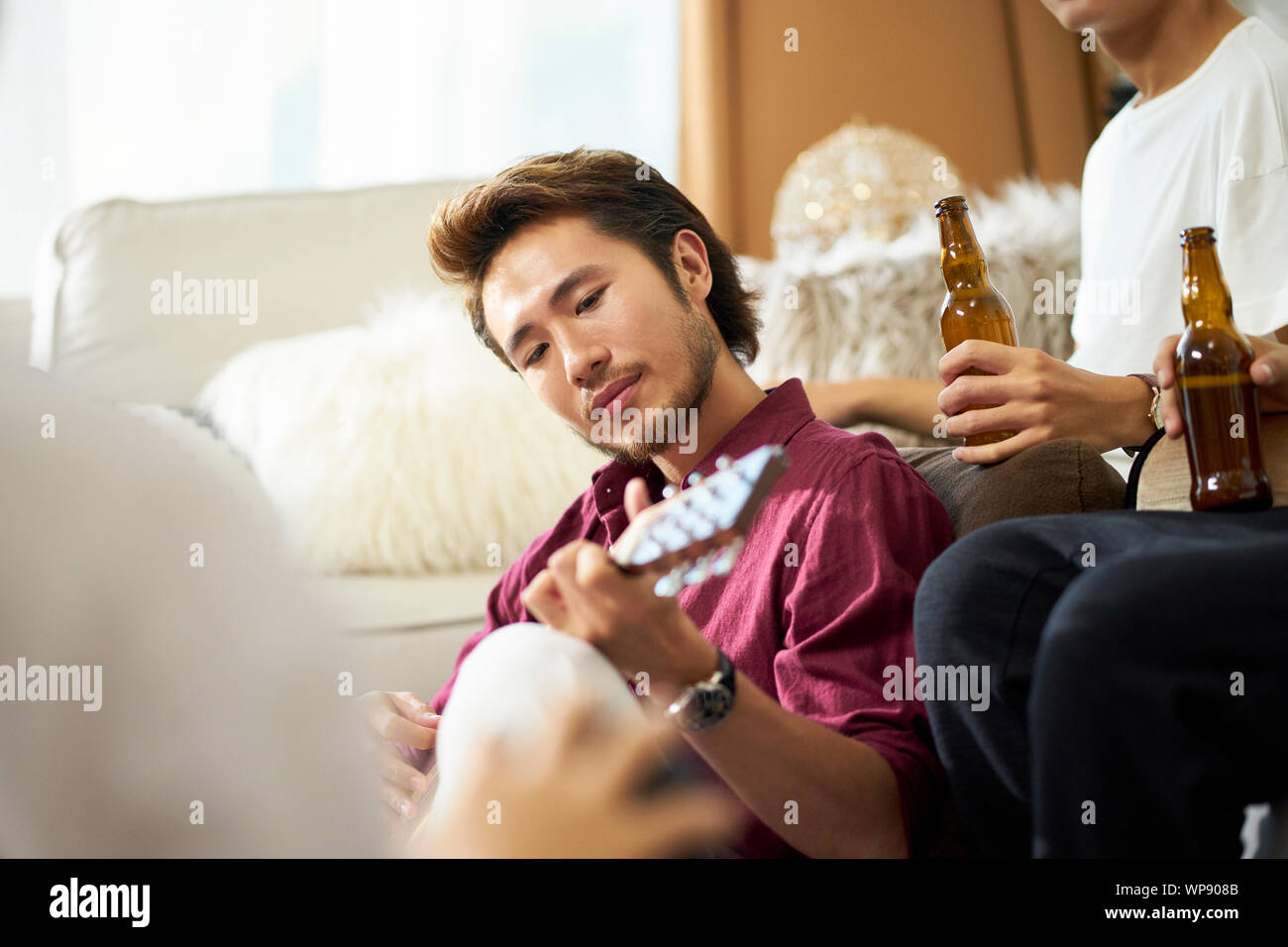 young asian adult men drinking beer at home Stock Photo
