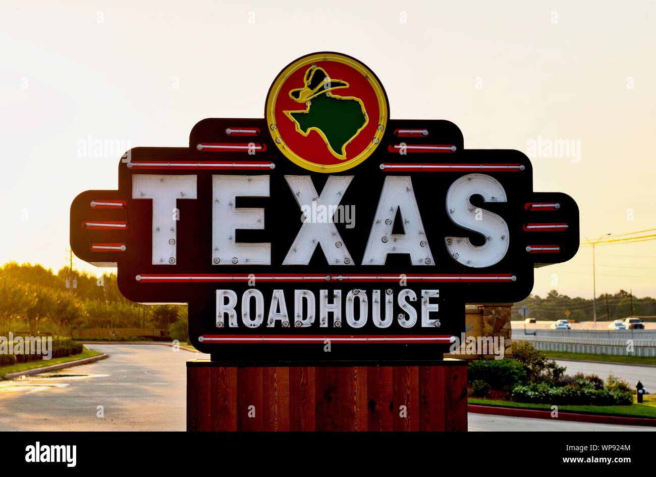 Houston, Texas/USA 09/06/2019: Texas Roadhouse restaurant sign on the side of a freeway in Humble, Texas during an early morning sunrise. Stock Photo