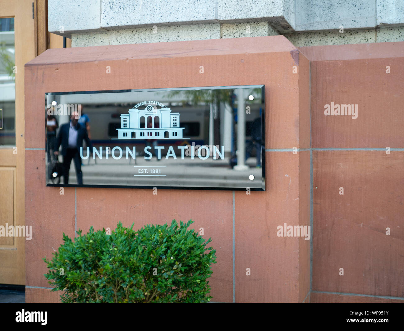 Denver Union Station sign outside of entrance with people walking in Stock Photo