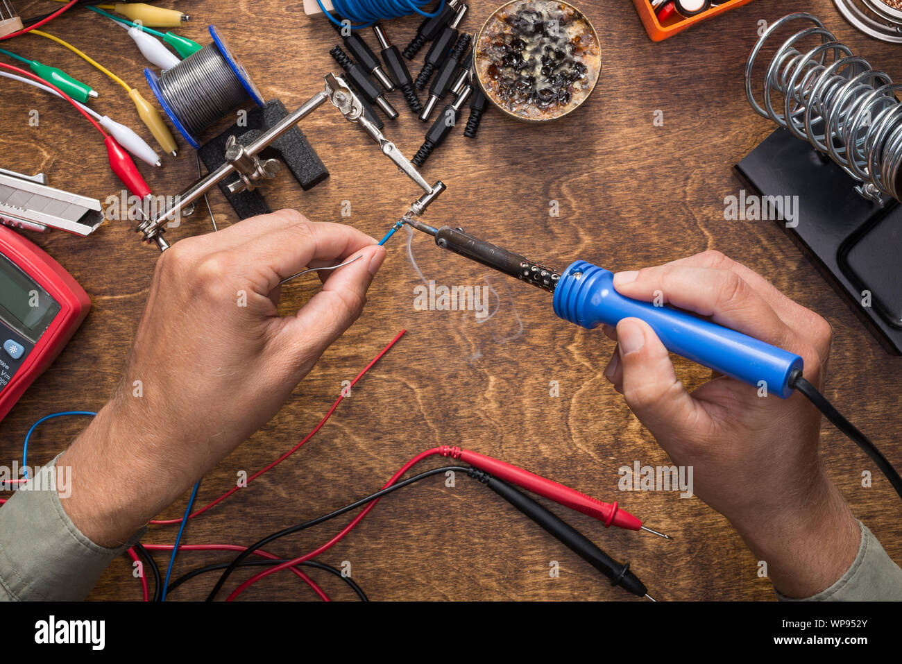 Hands soldering wires. Working with electronics. DIY, repair concept. Stock Photo