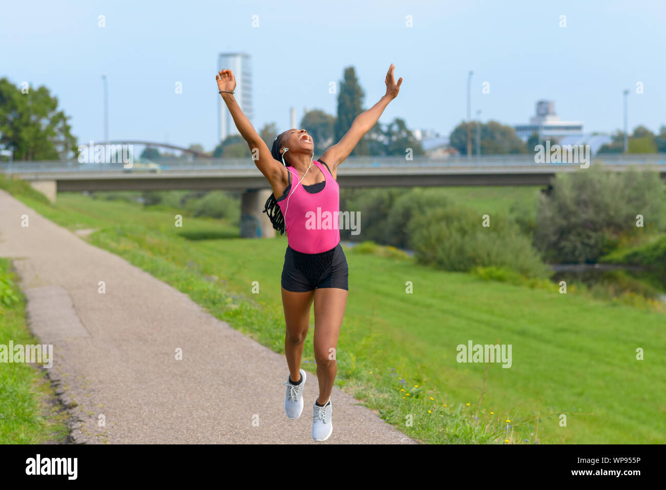 Exuberant young African woman full of vitality running along a rural path  cheering and laughing in a health and fitness concept Stock Photo - Alamy