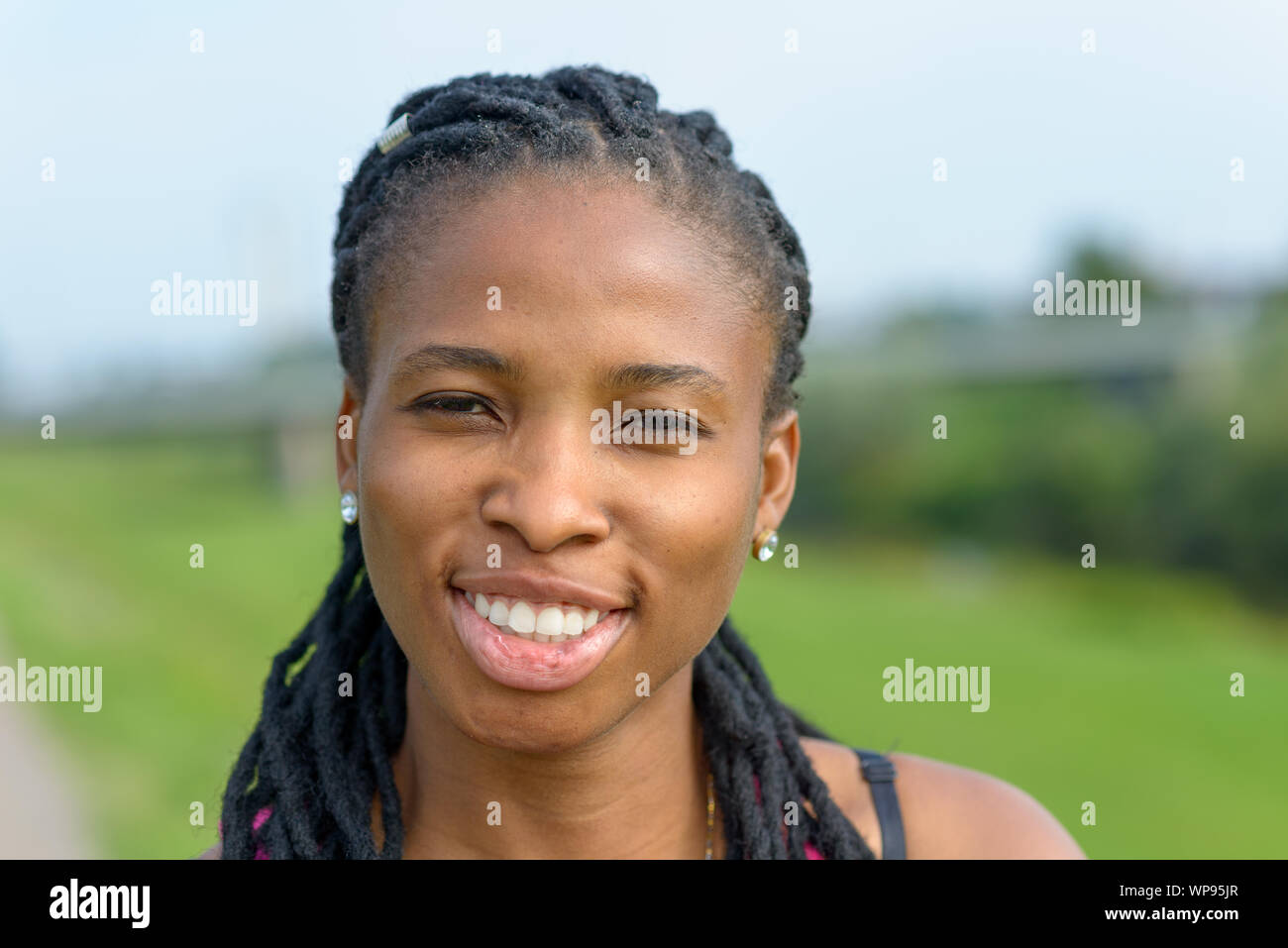 Portrait of an attractive African woman with a lovely friendly smile ...