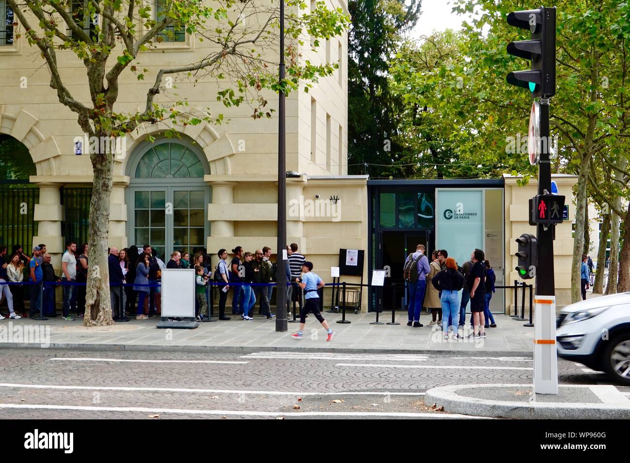 People standing in line waiting to enter the Paris, France