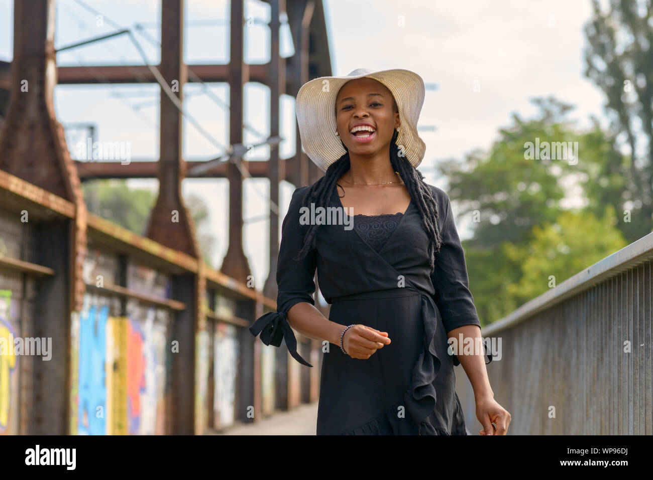Laughing vivacious young African woman wearing braided hair extensions