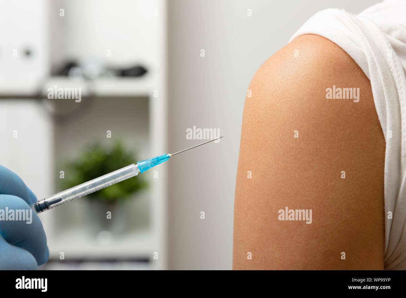 Doctor giving patient vaccine, flu shot. Doctor making a vaccination in the shoulder of patient Stock Photo