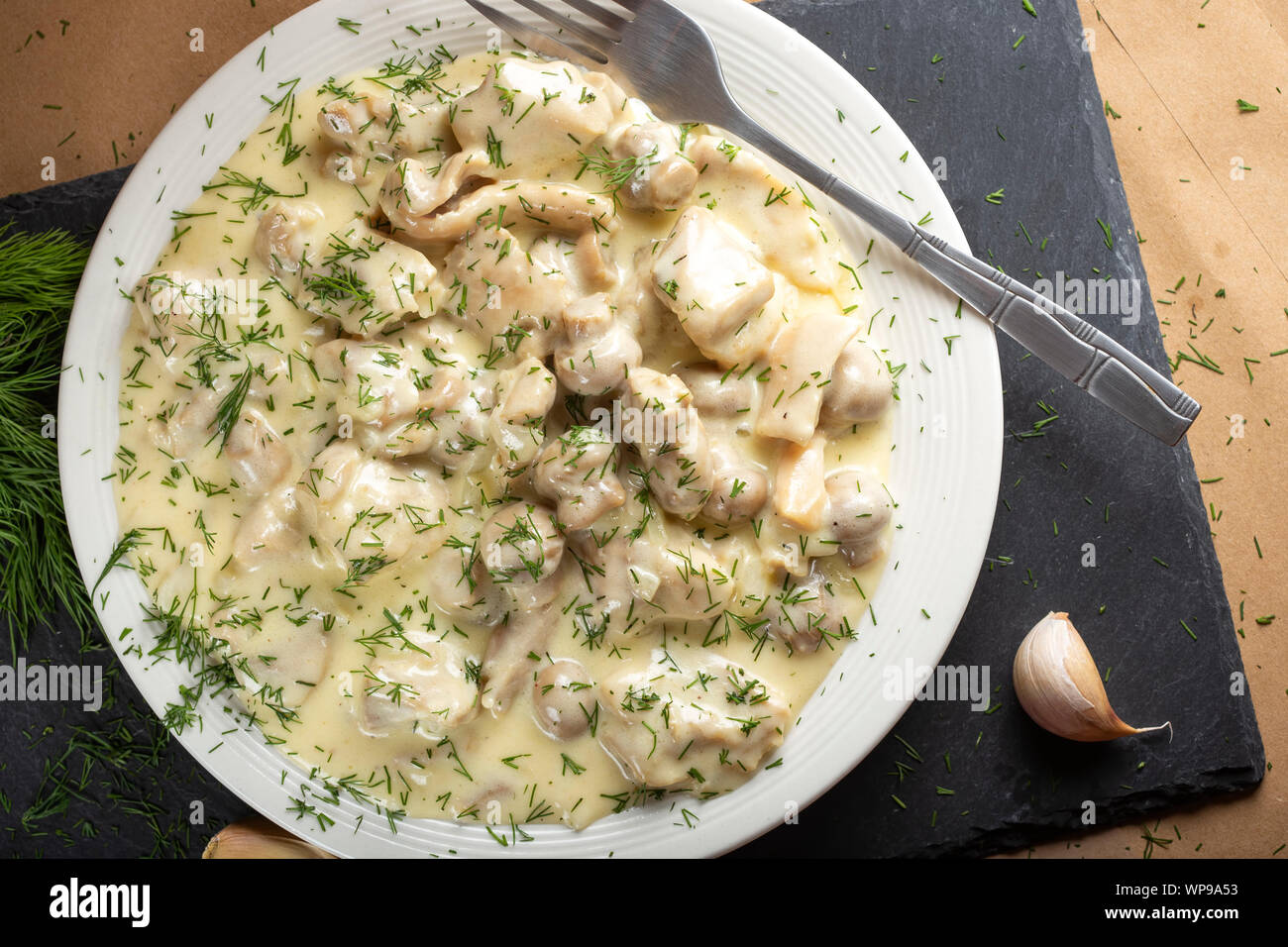Chicken meat with mushrooms, cream and chopped fresh green dill - top view Stock Photo
