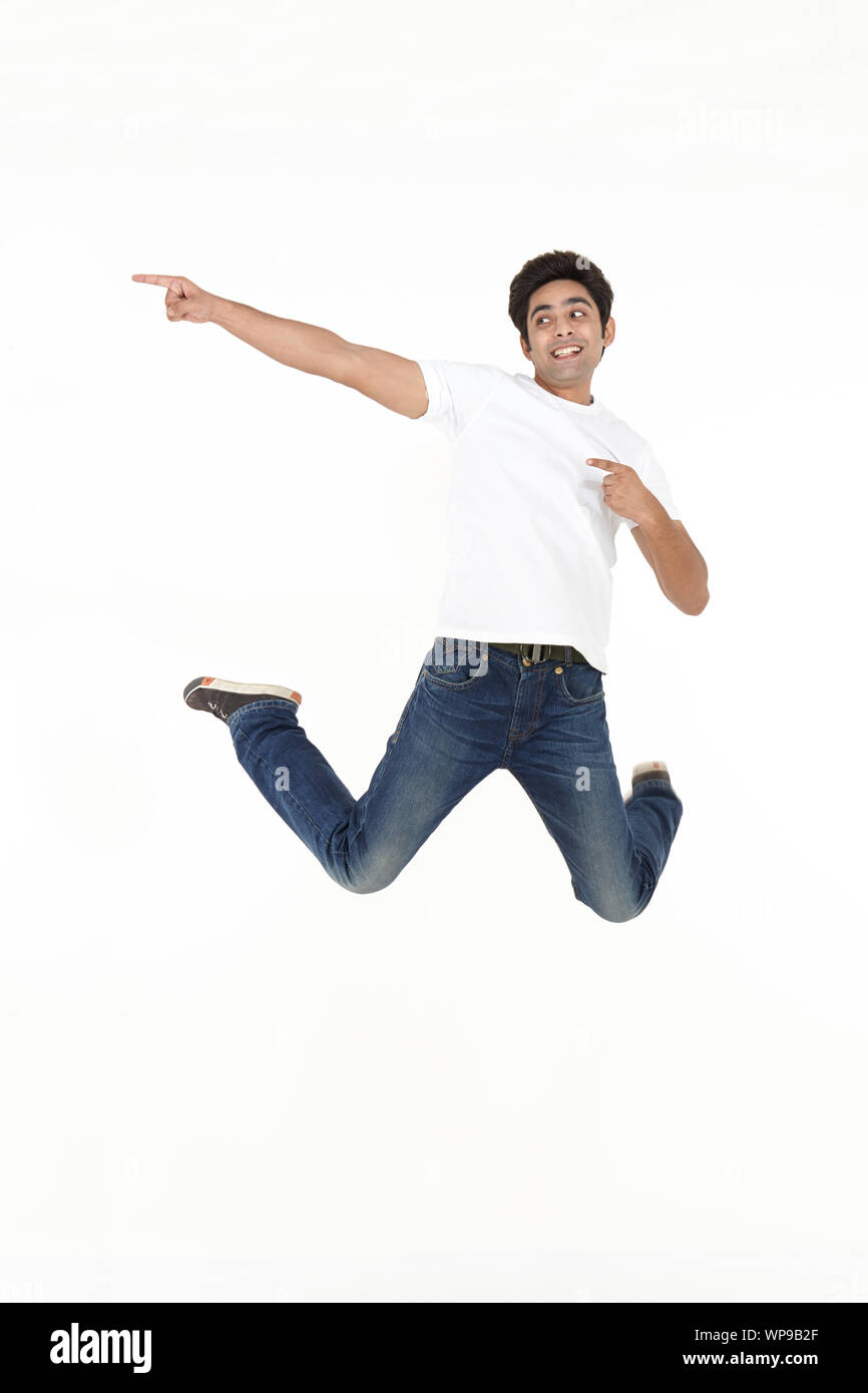Young man jumping in air and smiling Stock Photo