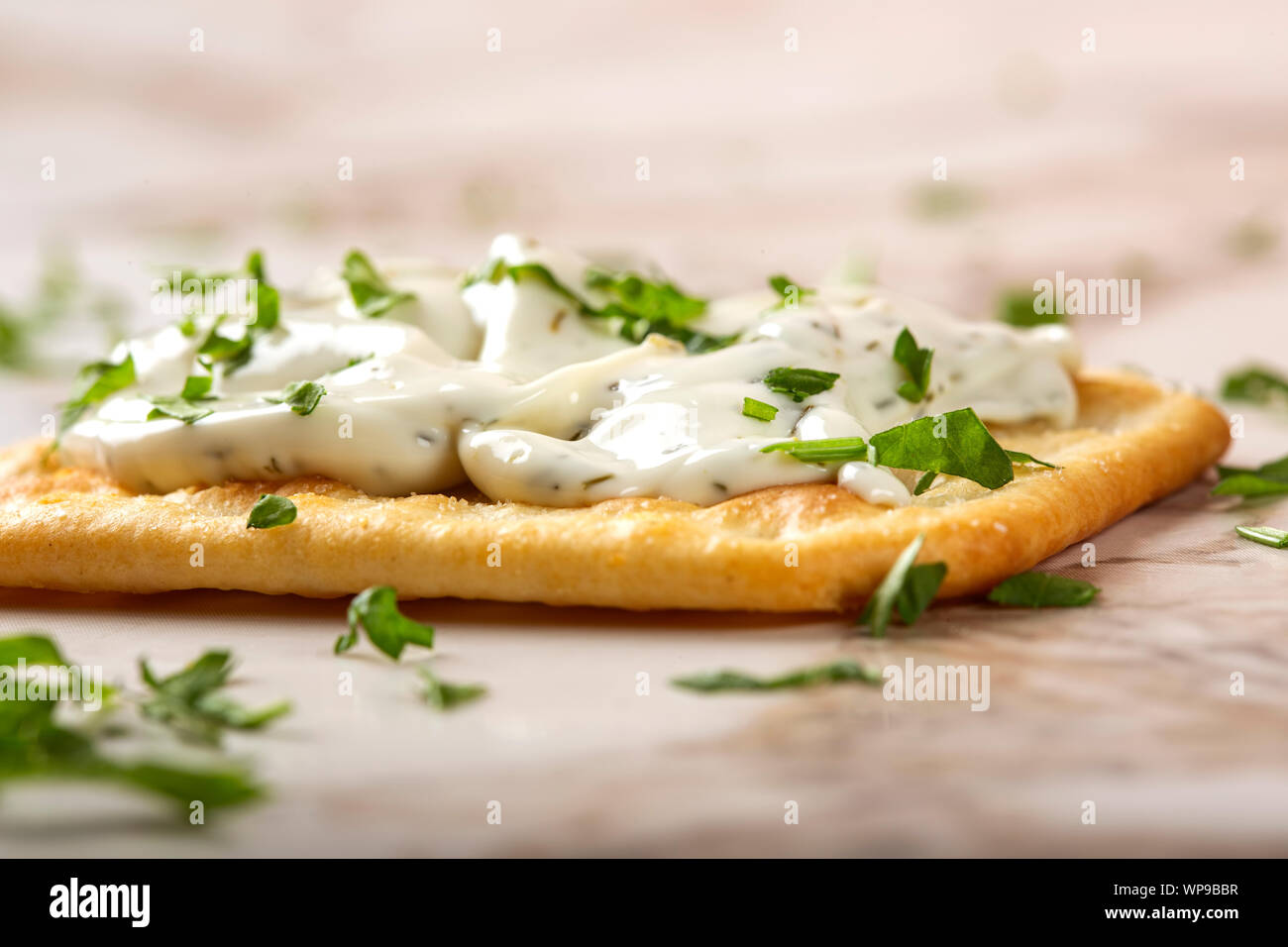 Salted craker with cheese cream and chopped parsley - close up view Stock Photo