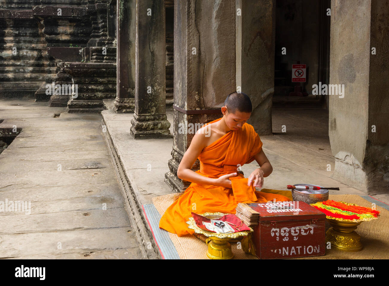 monk blessing Buddhist people in Central courtyard inside Angkor Wat ...