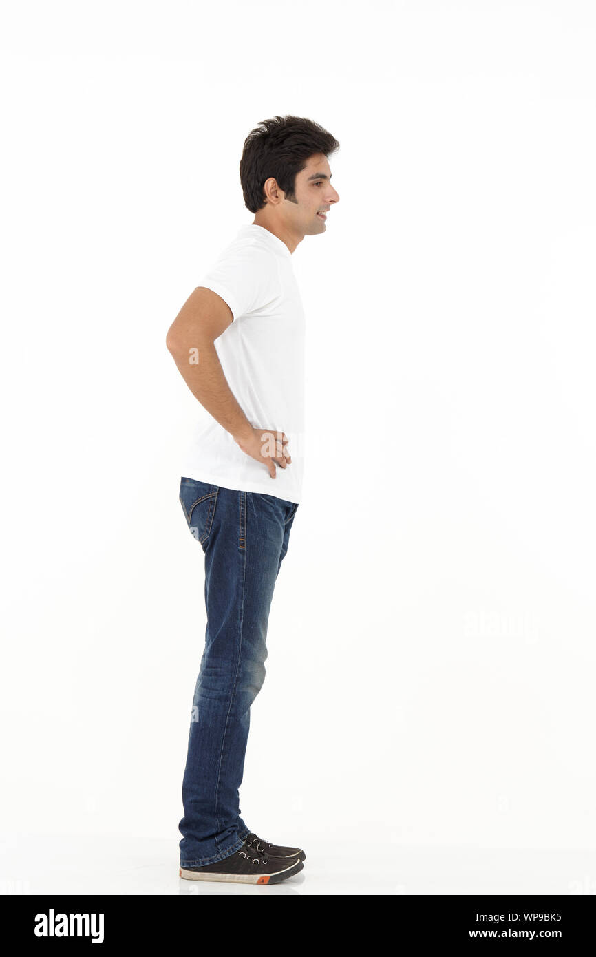 Young man thinking with his arms akimbo Stock Photo
