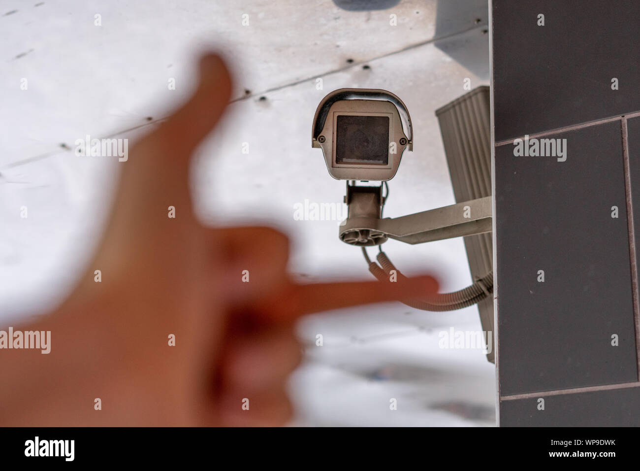 fpv hand show middle finger to cctv camera in public city streets Stock Photo