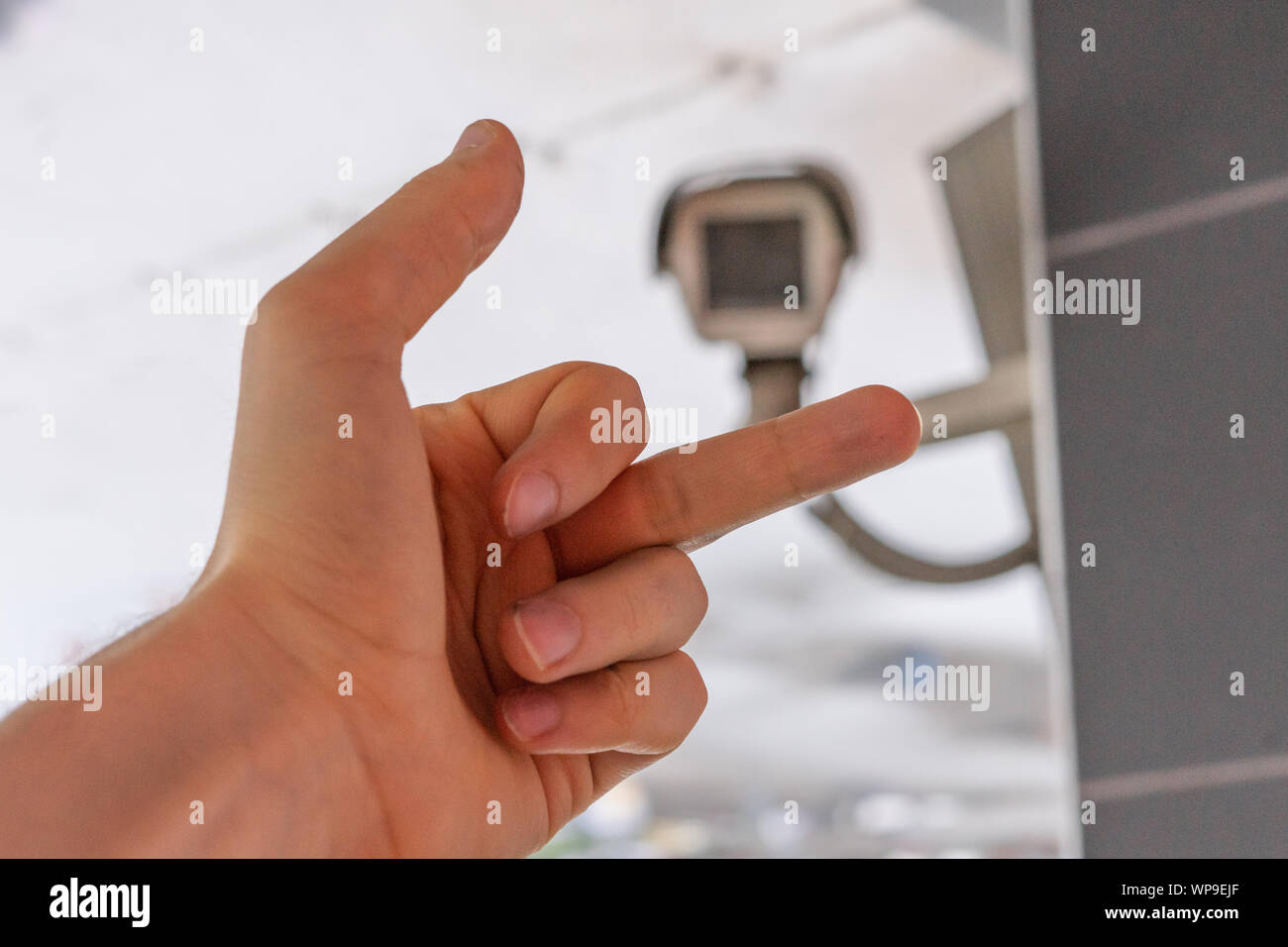 fpv hand show middle finger to cctv camera in public city streets Stock Photo