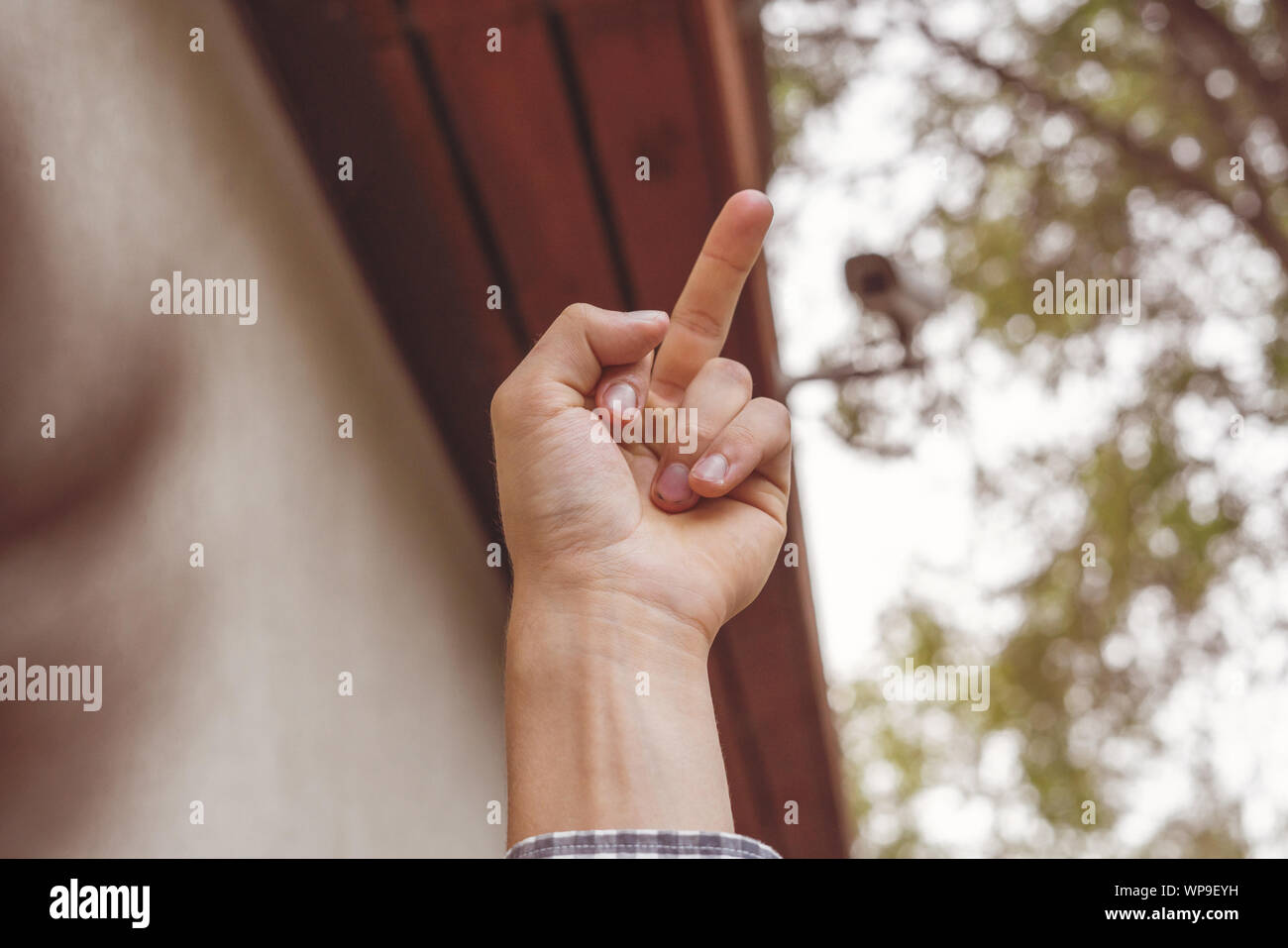 fpv hand show middle finger to cctv camera in public city streets Stock Photo