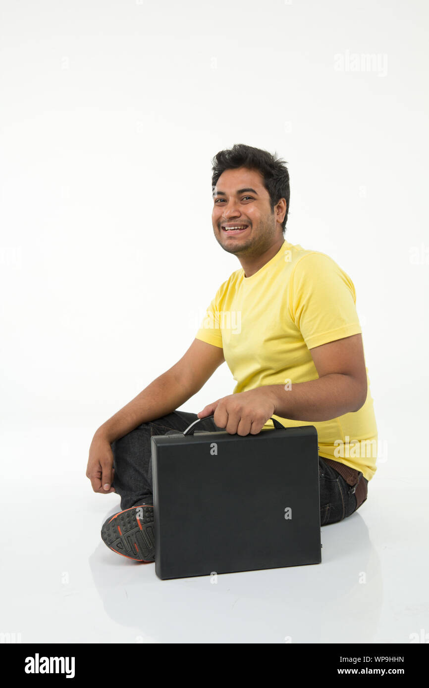 Young man smiling with suitcase Stock Photo