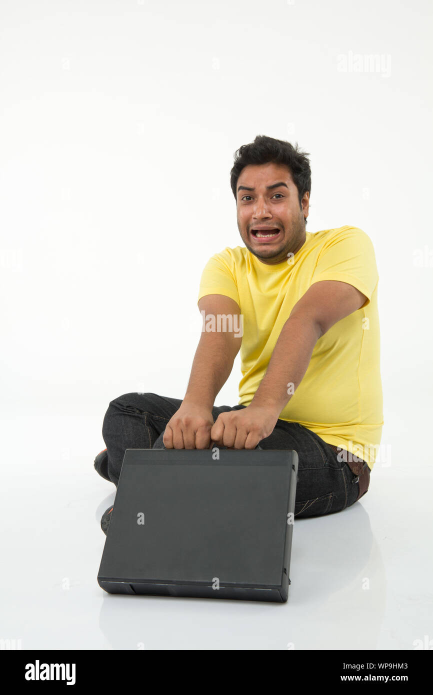 Young man looking worried with suitcase Stock Photo