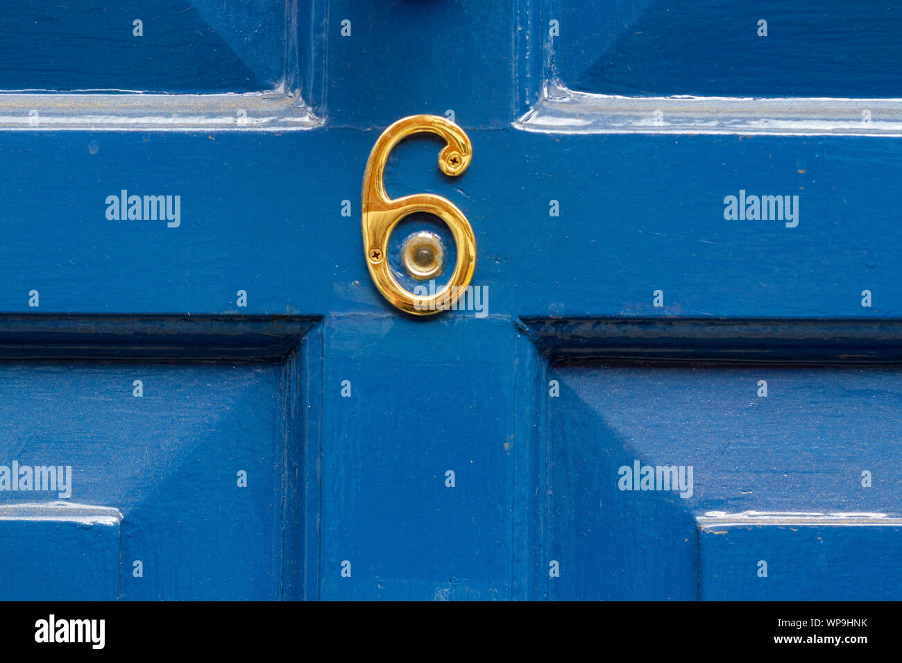 House number 6 in gold around a peephole Stock Photo