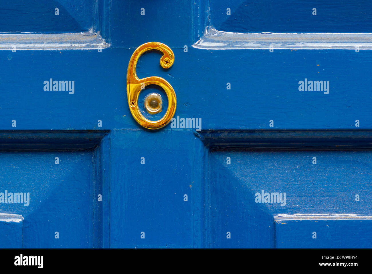 House number 6 in gold around a peephole Stock Photo